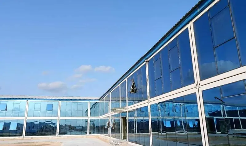 A modular office building with a continuous glazed facade under a blue sky